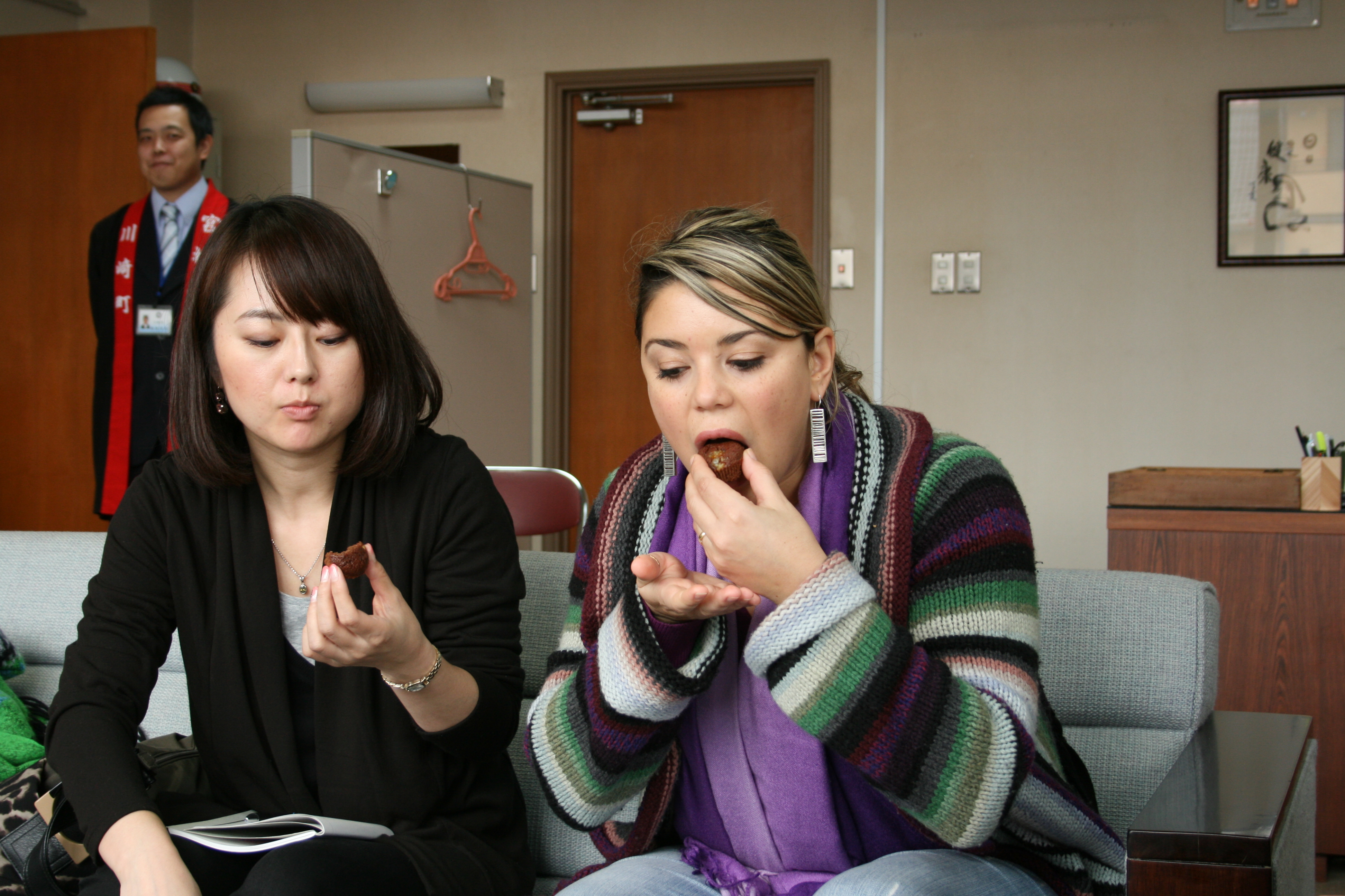 パトリシアさんが川崎町のチョコ菓子「初コラータ」を試食​している様子